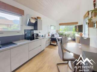 Discover this modern open-plan living space, featuring a sleek kitchen with integrated appliances and ample counter space.