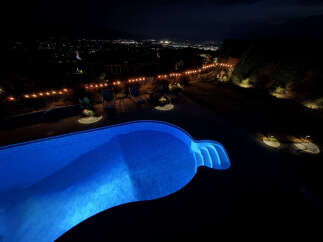 Experience luxury outdoor living with this stunning backyard oasis, featuring a beautifully illuminated swimming pool perfect for evening dips.
