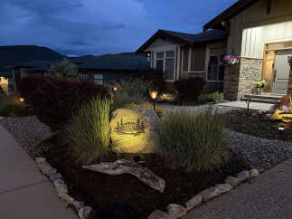 Enhance your home's curb appeal with this beautifully landscaped property, featuring a prominent address stone illuminated by landscape lighting.