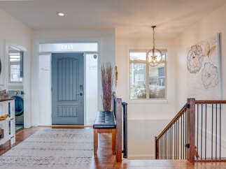 Step into this inviting entryway featuring a stylish gray front door and a convenient bench for seating.