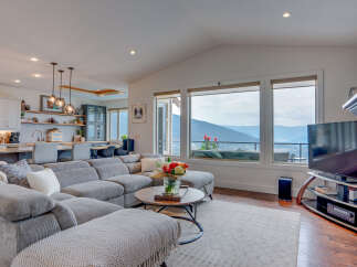 Experience breathtaking mountain views from this stunning living room, featuring a spacious sectional sofa perfect for relaxing.