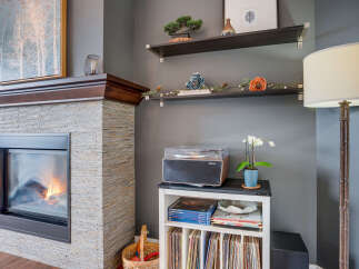 Cozy up by the modern stone fireplace, featuring a warm and inviting fire.