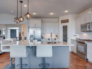 Experience luxury and functionality in this stunning modern kitchen, featuring a spacious granite island with comfortable bar seating perfect for casual dining or entertaining.