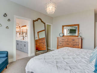 Experience luxury and comfort in this beautifully appointed bedroom, featuring a plush white duvet and elegant blue accent pillows.