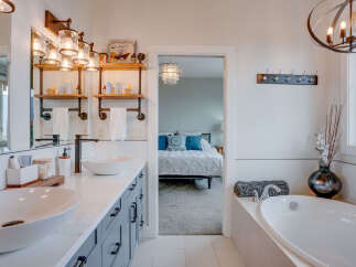Indulge in luxury with this stunning master bathroom featuring a spacious double vanity with elegant vessel sinks and ample storage.