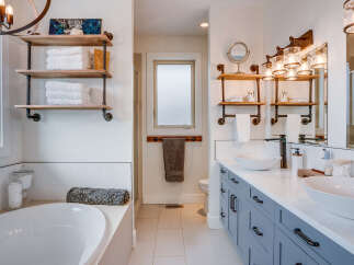 This luxurious bathroom features a freestanding soaking tub and a double vanity with vessel sinks, perfect for a spa-like experience at home.