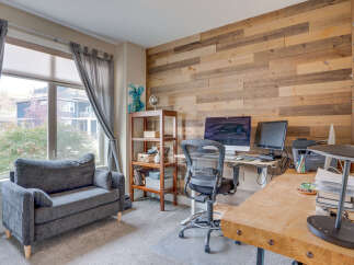 This home office features a rustic wood-paneled accent wall, creating a warm and inviting atmosphere.