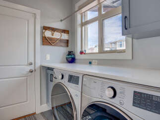 Discover the convenience of this modern laundry room, featuring a stacked LG ThinQ washer and dryer set.