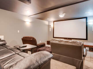 Experience cinematic bliss in this dedicated home theater room, featuring a large projection screen and comfortable seating arrangements.