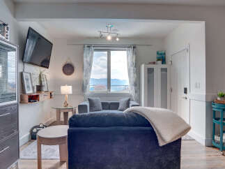Experience comfortable living in this inviting living room, featuring a plush navy sofa and a cozy grey sectional.