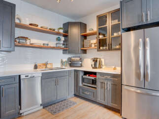 Experience modern living in this sleek kitchen, featuring stylish gray cabinetry and gleaming stainless steel appliances.