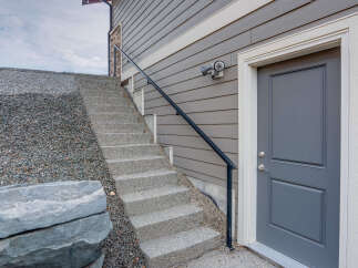Discover this charming home featuring a welcoming grey front door with classic paneling and a secure lockset.