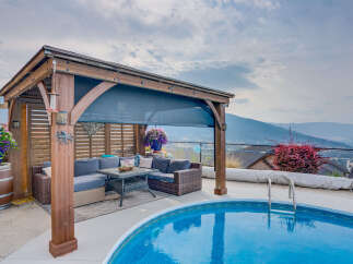 Enjoy outdoor living at its finest with this stunning backyard oasis, featuring a spacious covered patio with comfortable seating and a dining area.