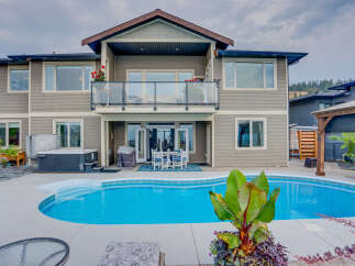 Experience luxurious outdoor living with this stunning backyard featuring a sparkling swimming pool and a relaxing hot tub.