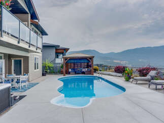 Experience luxury outdoor living with this stunning backyard oasis, featuring a sparkling freeform swimming pool and a covered gazebo perfect for entertaining.