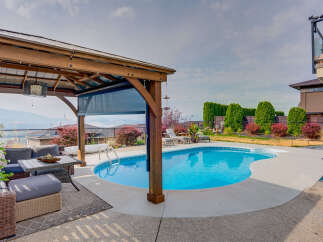 Enjoy resort-style living in this stunning backyard oasis, complete with a sparkling swimming pool and a covered patio area perfect for entertaining.