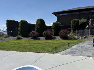This stunning property features a beautifully landscaped backyard with a lush green lawn, perfect for outdoor activities.