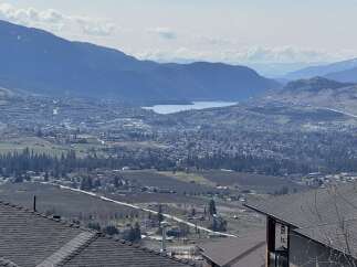 Experience breathtaking panoramic views from this stunning property, overlooking a vibrant valley and a serene lake.