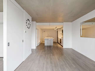 Experience modern living in this spacious open-concept apartment featuring a sleek kitchen with an island and contemporary appliances.