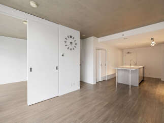 Experience modern living in this spacious open-concept condo, featuring a sleek kitchen island perfect for entertaining.