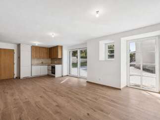 Discover modern living in this beautifully renovated space featuring a sleek, integrated kitchen with ample cabinet storage and a built-in oven.