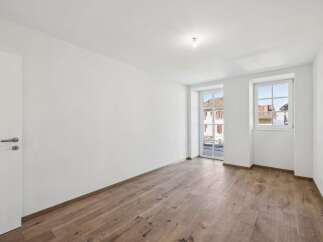 Discover this bright and airy room featuring a modern white door and elegant wooden flooring.