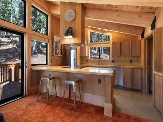 Experience rustic charm in this mountain kitchen featuring warm wood cabinetry and a spacious granite island with seating.