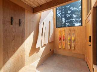 This entryway features a unique wooden wall art and three vintage water skis, adding a rustic charm.