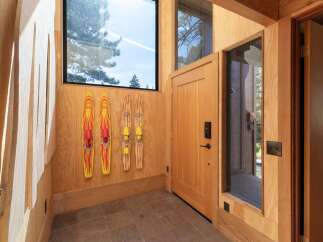 Experience the perfect blend of rustic charm and modern convenience in this entryway, featuring natural wood paneling and a large window offering scenic views.