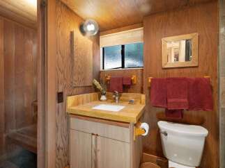 This rustic bathroom features warm wood paneling throughout, creating a cozy and natural ambiance.