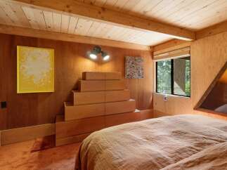 This cozy bedroom features warm wood paneling throughout, creating a rustic and inviting atmosphere.