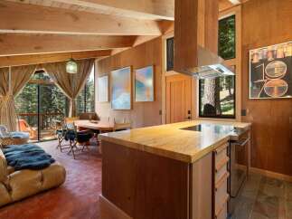 Experience rustic charm in this mountain retreat, featuring a cozy living area with a plush sofa and a hanging chair, perfect for relaxing.
