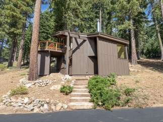 Nestled amongst towering pine trees, this unique home offers a secluded mountain retreat.