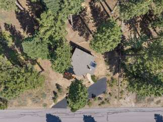 Discover this charming home nestled amongst mature pine trees, offering a serene and private setting.