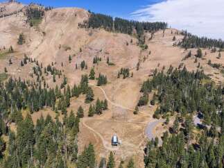 Discover this stunning mountain property featuring a ski lift and a winding road, perfect for outdoor enthusiasts.