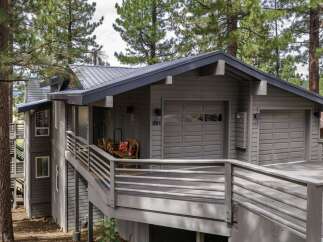 Discover this charming mountain home featuring a durable metal roof and a spacious two-car garage, perfect for storing vehicles and outdoor gear.