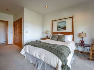 Experience comfort and style in this inviting bedroom, featuring a cozy four-poster bed adorned with a plush knit throw.