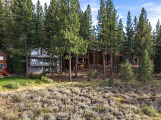 Nestled among towering pine trees, this multi-level home offers stunning natural beauty and ample living space.