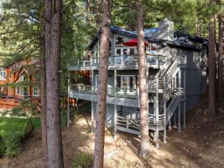 Nestled amongst towering pine trees, this multi-level modern home offers stunning views and ample outdoor living space.