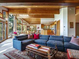 Experience rustic charm in this spacious living area, featuring a large sectional sofa perfect for gatherings and a cozy rug underfoot.