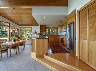 Experience the warmth of this inviting kitchen and dining area, featuring rich wood cabinetry and a spacious dining table perfect for gatherings.