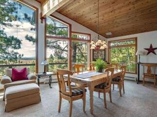 Experience breathtaking views from this stunning dining room, featuring expansive windows that showcase the surrounding natural beauty.