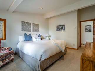 Experience comfort and style in this inviting bedroom, featuring a plush queen-size bed adorned with decorative pillows and a cozy throw.