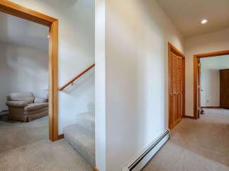 Step into this inviting hallway featuring a plush carpeted staircase leading to the upper level.