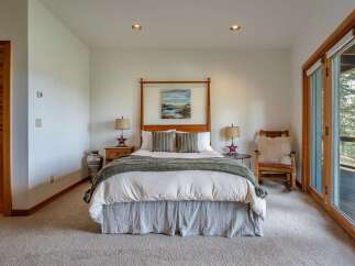 This charming bedroom features a cozy king-size bed with a rustic wooden canopy, complemented by two bedside tables with star-shaped lamps.
