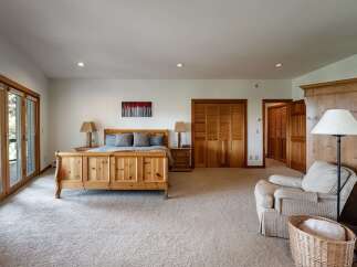 Experience ultimate comfort in this spacious bedroom featuring a charming wooden sleigh bed and plush carpeting.