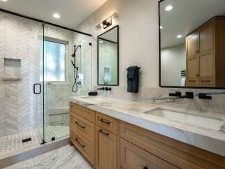 Experience modern luxury in this stunning bathroom featuring a spacious walk-in shower with herringbone tile and a sleek glass enclosure.