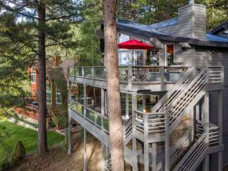 Experience elevated living in this stunning multi-level home, nestled amongst tall pine trees.