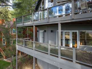 Experience breathtaking views from multiple levels of this stunning home, featuring expansive decks with modern glass railings perfect for entertaining.