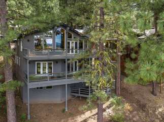 Nestled amongst tall pine trees, this modern home offers stunning natural views from its multiple levels of decking.